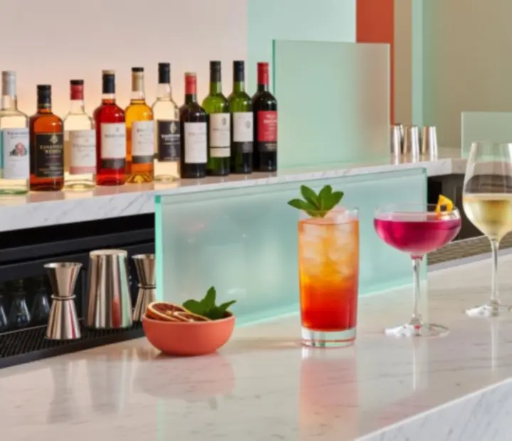 Modern bar counter with colourful cocktails and wine glasses